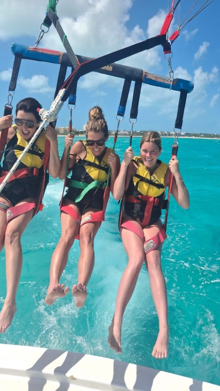 Family enjoying a parasailing boat trip in Grace Bay, Providenciales, Turks and Caicos with Captain Marvin's Watersports.